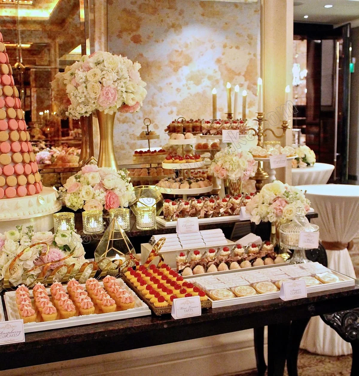 Mesa de postres presentada de forma atractiva para un evento